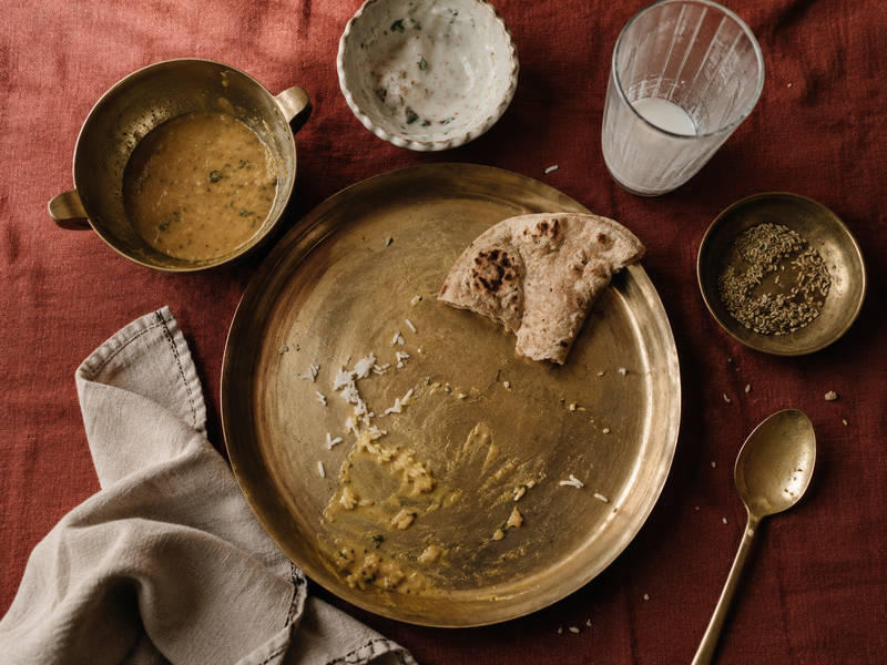 the aftermath of the meal. The visual moment every reader recognises — the table after the biryani is gone. Empties, crumbs, a folded napkin. 